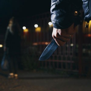A person with a knife in the dark, possibly for self-defense - The Zorrilla Law Firm
