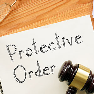 Protective Order document shown on paper related to COCCA investigation defense