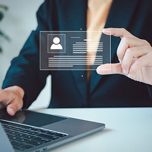 A person holds a transparent digital card with a profile icon and personal data, symbolizing identity